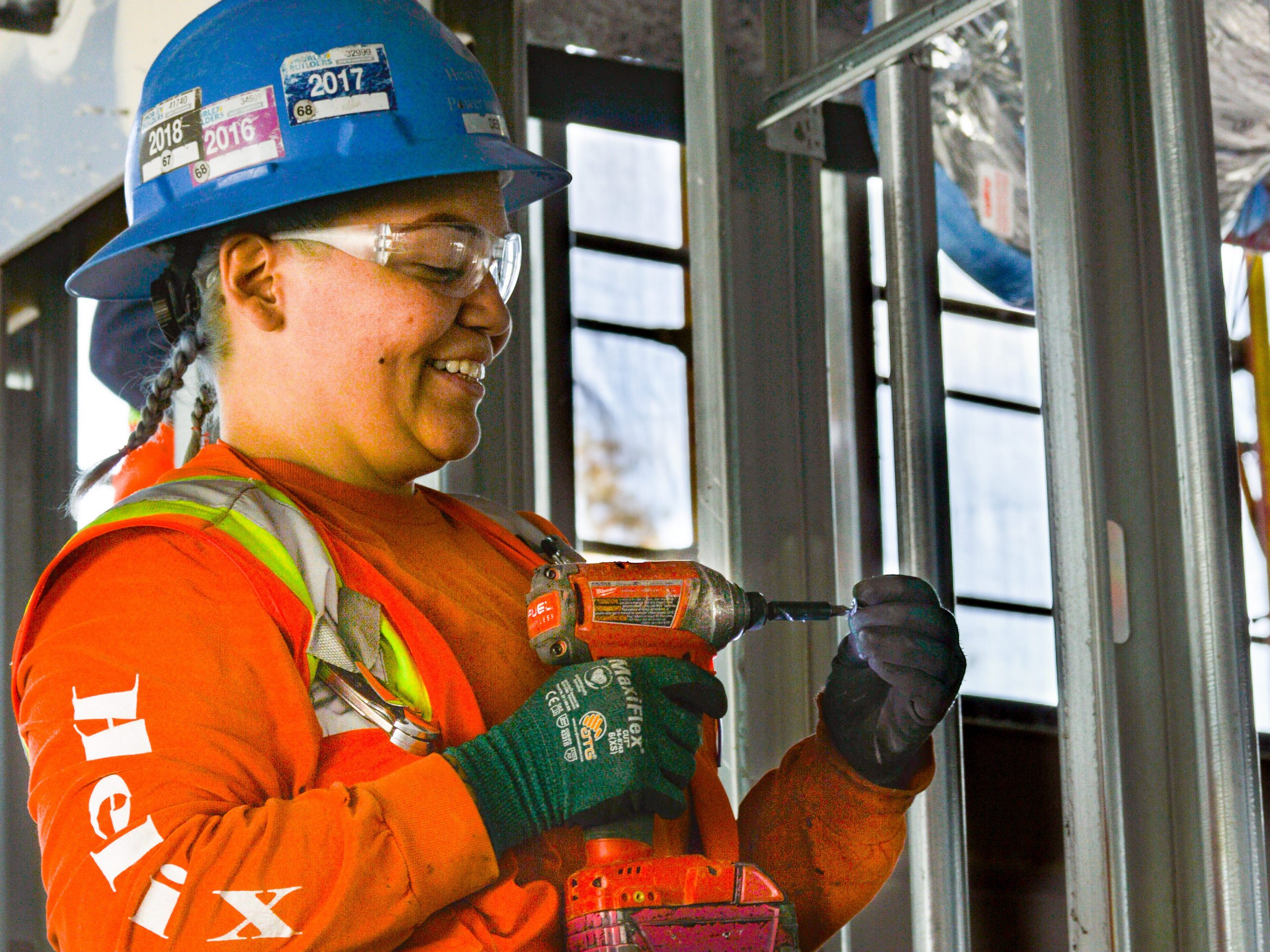 A Helix Electric employee uses a drill at a job site